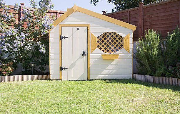 Petit abri de jardin en bois dans le jardin d'une maison