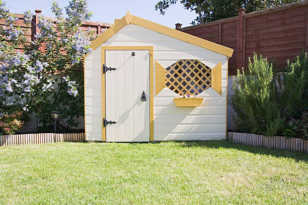 Petit abri de jardin en bois dans le jardin d'une maison